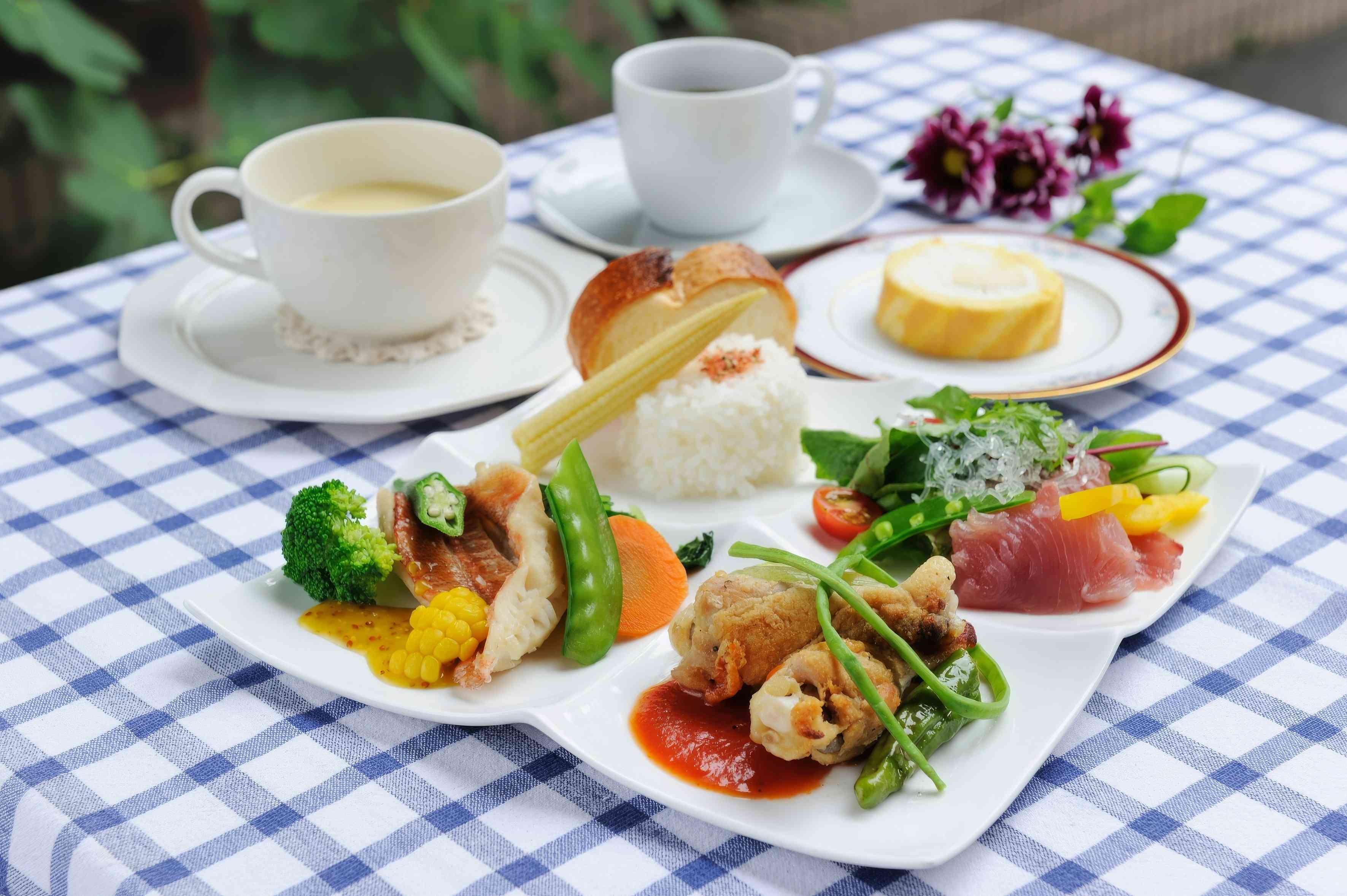 Camping plates, bowls, mugs, and utensils on a wooden outdoor table